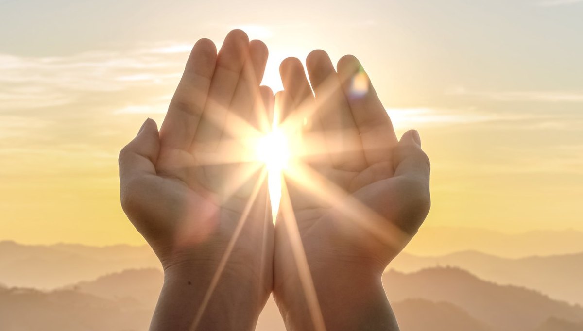 Geöffnete Hände, dazwischen die Sonne